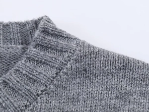 Gros plan détaillé du col rond côtelé et de la texture en maille douce de ce pull gris