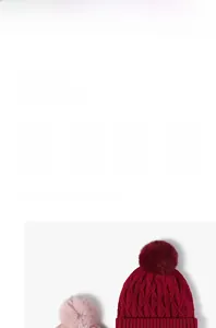 Detail of cable knit pattern and faux fur pompom on thick winter thermal beanie hats