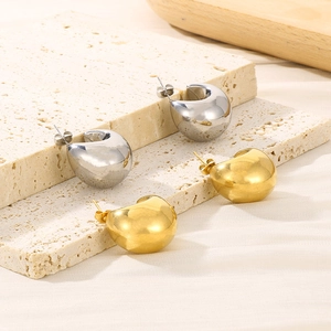 Polished hollow semi-circle stud earrings in gold and silver finish on a stone base