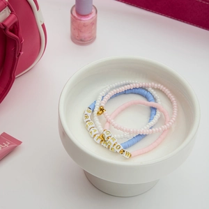 Détail de bracelets perlés multicouches avec lettres BREATHE et GROW et perles en argile
