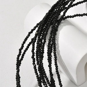 Polished black mother of pearl round beads 2mm on minimalist white sculpture