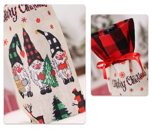 Detail of burlap Christmas wine bottle cover with gnome print and red ribbon bow