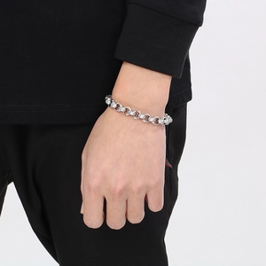 Gros plan d'un bracelet gourmette en acier titane argenté avec fermoir à bascule au poignet