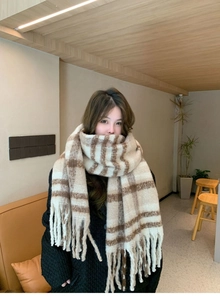 Close-up of soft beige and brown plaid scarf with tassels for winter fashion style