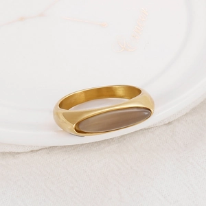 Macro shot of minimalist gold stainless steel ring with oval brownish translucent gemstone