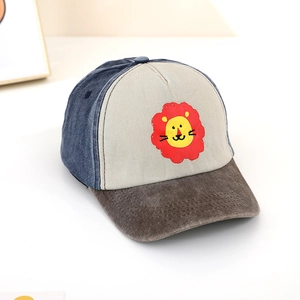 Dettaglio del cappellino per bambini in tessuto color-block e toppa con leone ricamato
