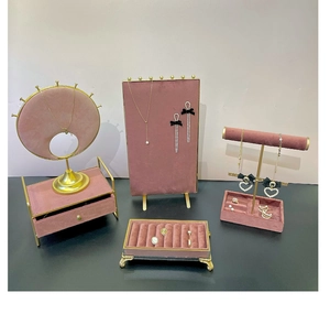 Detail view of pink velvet jewelry display stands with gold metal frames for necklaces