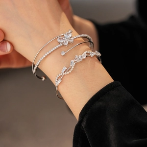 Details von drei verstellbaren Silberarmbändern mit Zirkonia Schmetterling und Blumen