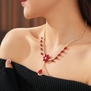 Detail of flower and water drop pendant necklace with red gemstone and sparkling zircon