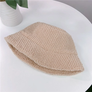 Flat lay of a beige fleece bucket hat with plush texture on a white surface