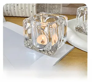 Close-up of ice cube glass candle holder with tea light on a wooden minimalist table