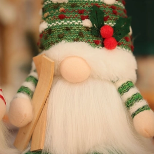 Close-up of knitted Christmas gnome plush with festive red and white wool textures