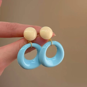 Detail of vintage resin hoop earrings featuring beige beads and blue hollow rings