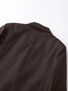 Dettaglio ravvicinato del bavero del blazer marrone scuro e della trama del tessuto