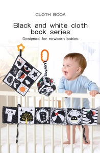 High-contrast black and white newborn cloth book set shown in a crib with a baby