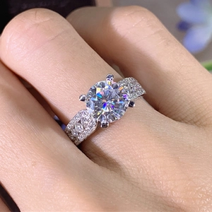 Detailed close-up of a classic four-prong zircon ring with a triple-row pave band worn on a finger