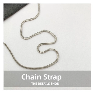 Detailed close-up of a silver-tone metal snake chain shoulder strap with high-gloss finish