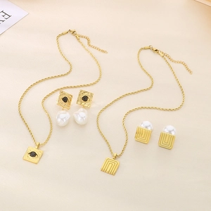 Detail of vintage gold titanium steel necklace and pearl earrings with evil eye motifs
