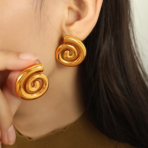 Boucles d'oreilles spirale plaqué or 18K au design conque portées par un mannequin