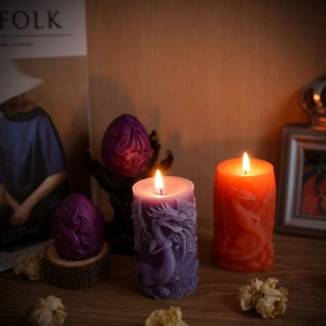 Relief dragon cylinder candles and eggs set in purple and orange on wooden table