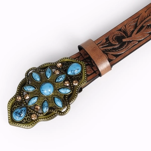 Macro view of vintage western belt with turquoise buckle and floral embossed leather