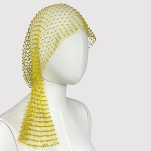 Detailed close-up of yellow beaded mesh headpiece texture and woven craftsmanship