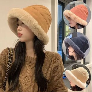 Detail showing plush bucket hats in khaki, pink, black, and beige with soft textures