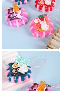 Detailed close-up of mini strawberry cream cake keychain charms on display stand