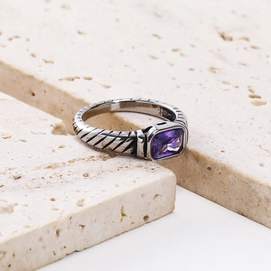Detailed macro view of vintage cable ring with rectangular purple stone and 18k gold accents