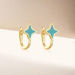 Macro shot of S925 silver gold-plated hoop earrings with blue enamel star detail