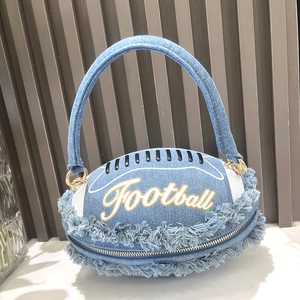 Macro detail of rugby-shaped denim handbag with fringe edges and football embroidery