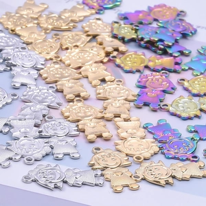 Macro detail of cartoon girl pendants in gold, silver, and rainbow stainless steel finishes