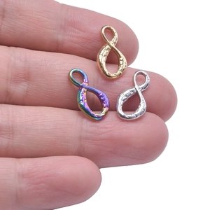 Macro shot of 304 stainless steel infinity charms in gold silver and rainbow textures
