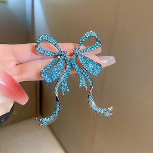 Sparkling blue crystal bow stud earrings with a shiny silver metallic finish for women
