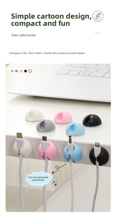 Silicone cable organizers in five colors neatly arranged on a white desk for cord management
