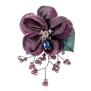 Elegant purple lace flower brooch with crystal center and beaded tassels on white backdrop