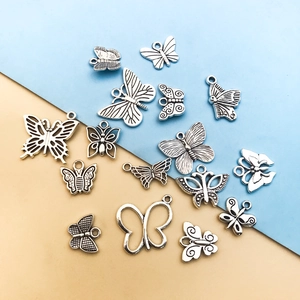 Flat lay of Tibetan silver butterfly pendants for DIY jewelry making on blue yellow background