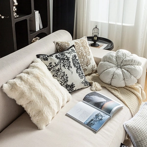 Close-up of premium embroidered cushions and faux fur pillows on a beige sofa