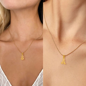 Detailed close-up of golden stainless steel necklace with S and A letter pendants