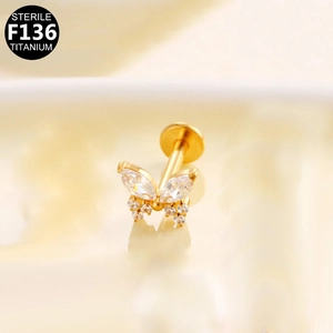 Macro shot of F136 titanium gold butterfly labret stud with sparkling zircon stones