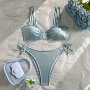 Detail of light blue glitter fabric two-piece bikini with side-tie bottoms on silk
