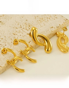 Macro shot of 18k gold plated stainless steel earrings with interlocking C and waterdrop design