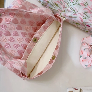 Detail of pink heart jacquard fabric, metal magnetic buckles, and bag interior