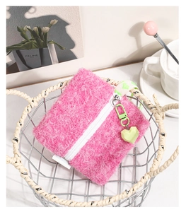 Pink plush square coin purse with green heart charm in a decorative wire basket