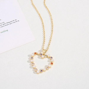 Elegant gold heart pendant necklace featuring inlaid pearls and multi-colored zircons