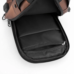 Internal view of the brown leather chest bag showing black lining and zip pocket detail
