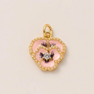 Macro shot of a 18K gold plated pansy flower pendant with pink enamel and pearls
