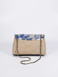 Close-up of beige woven shoulder bag with blue floral sequin embroidery and gold chain