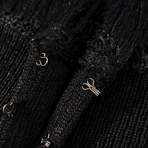 Détail du tissu en maille noire avec fils scintillants et fermeture à crochet en métal