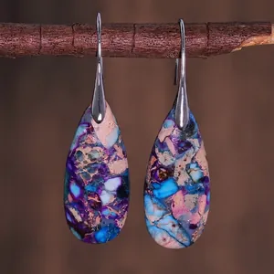 Detail of teardrop earrings with colorful natural stone texture on rustic wood